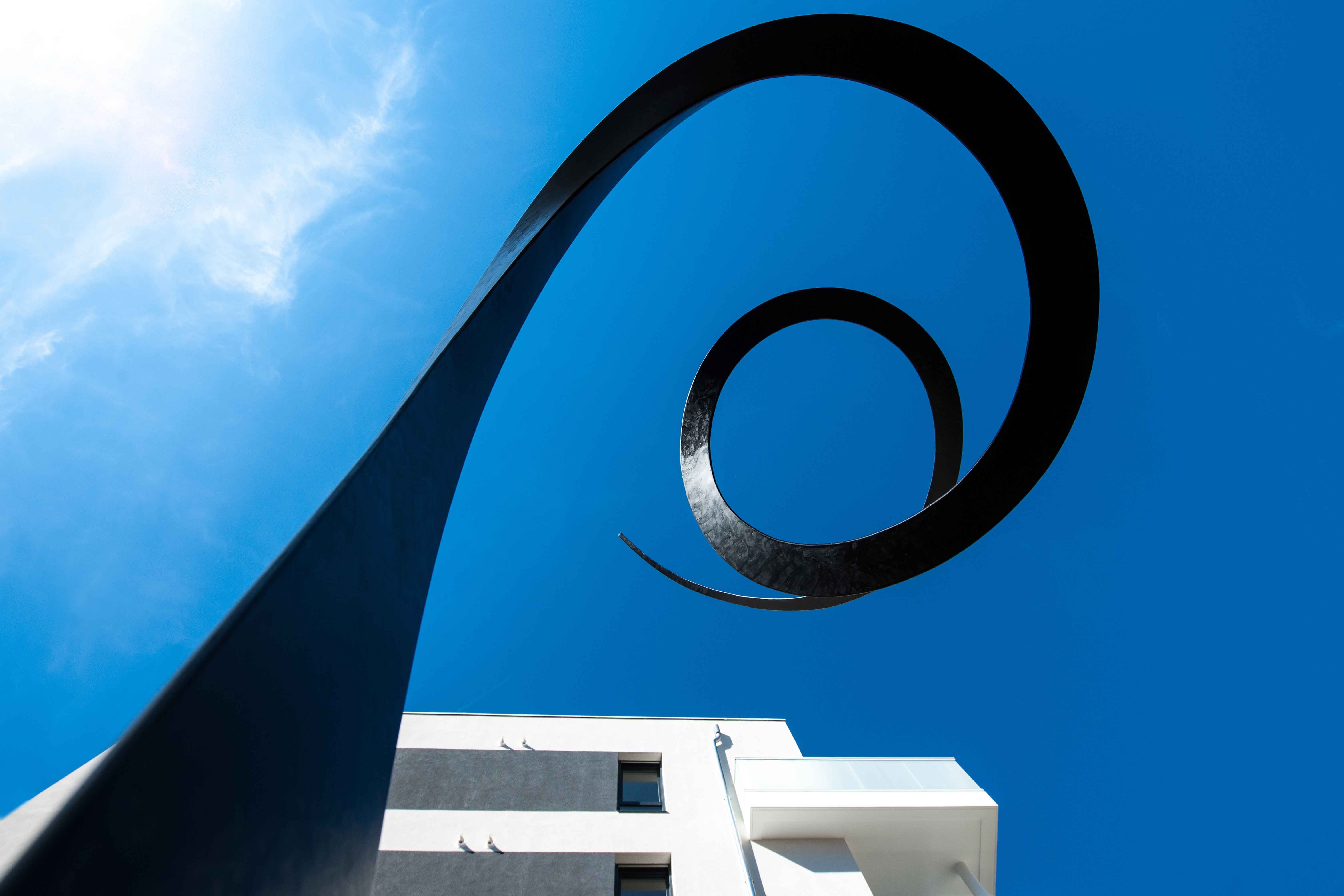 Mise en oeuvre d’art sculpture batiment promoteur immobilier ciel bleu soleil metal béton