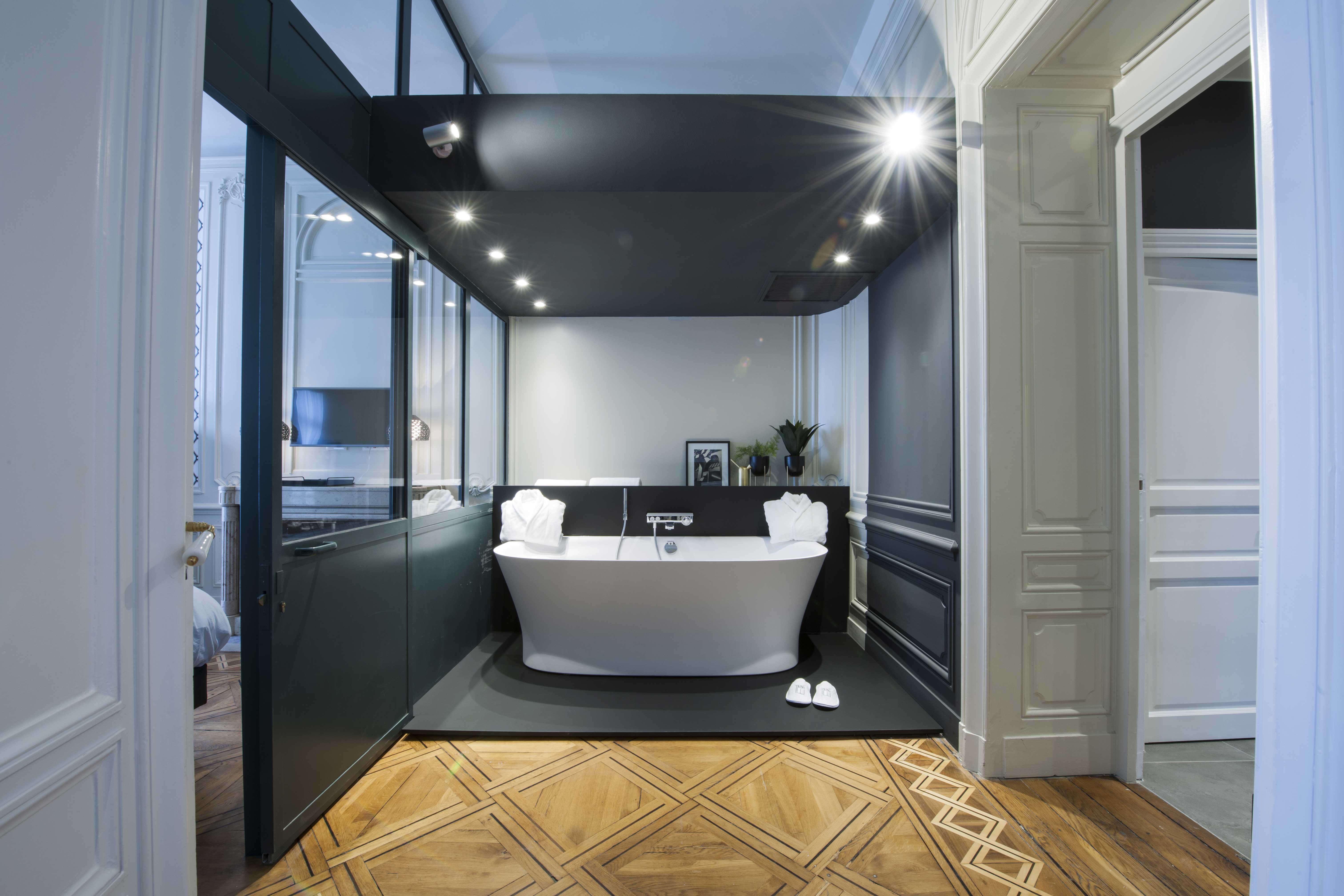 baignoire salle de bain hotel suite design architecture intérieur lumière lampe parquet noir blanc verrière